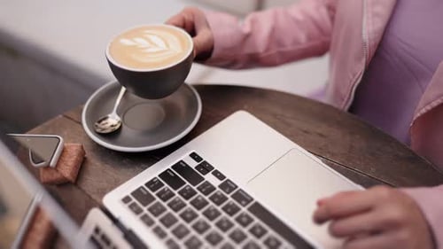 Young Adult Working on a Laptop with Coffee