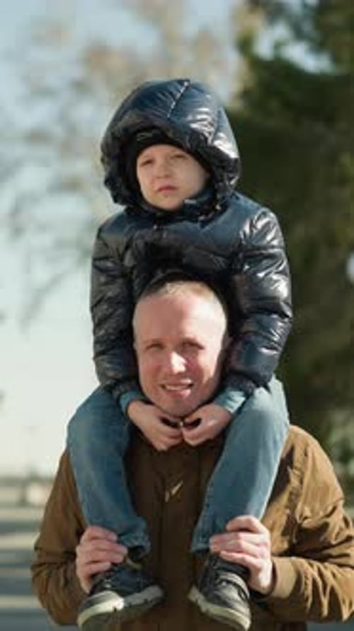 Father and Child Enjoying a Walk in the Park on a Winter Day