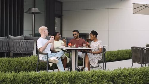 Diverse friends enjoying a sunny afternoon at an outdoor cafe