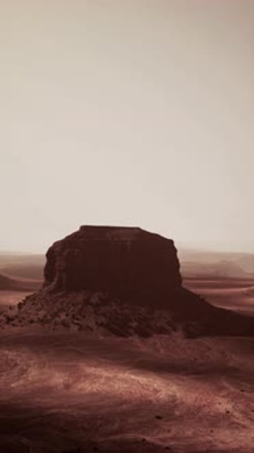 Massive Rock Formation Towering in Desert Landscape