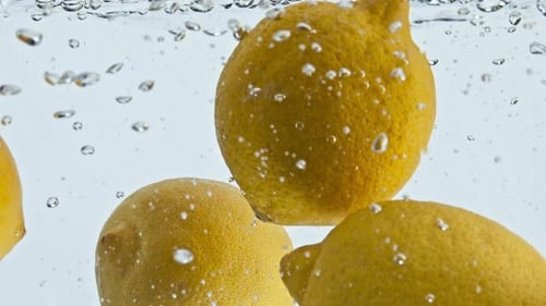 Fresh Lemons Floating in Water with Bubbles