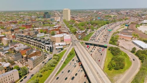 Wide multiple-lane roads with numerous cars. Automobiles driving in both directions on the roads.