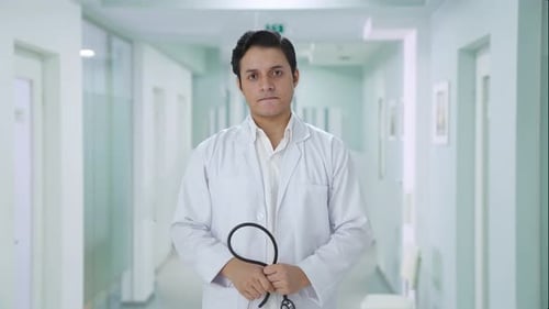 Male Doctor with Stethoscope Standing in Hospital Hallway