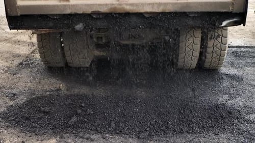 Paving Truck Laying Fresh Asphalt on Street