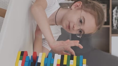 Kleines Mädchen mit Familie spielt Jenga-Spiel