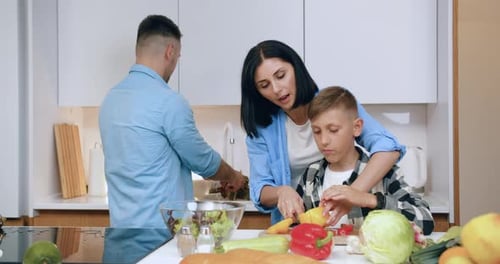 Family Making Salad Together in Bright Kitchen