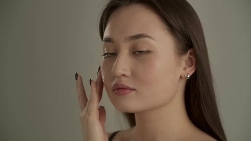 Woman Applies Lotion to Face, Close Up