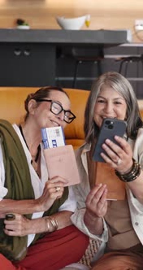 Two Smiling Women Holding Passports Ready to Travel