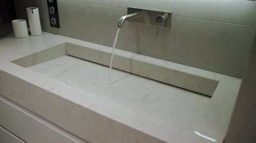 Composite Material Sink with Water Running From Faucet