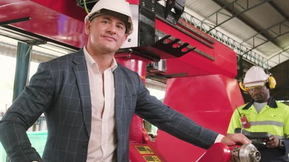 Male entrepreneur is proud of robotic arm in mechanical manufacturing ...