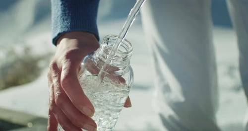 Cinematic Close Up shot of Female Hands Filling a Glass Bottle with Fresh Pure Cold Water fr