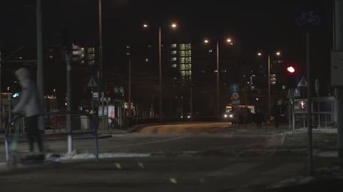 De noche en una intersección concurrida en una tarde de la ciudad. Noche oscura con luces nocturnas y gente yendo