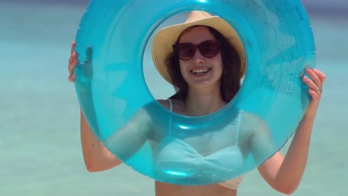 Woman Smiling with Swim Ring on Sunny Beach