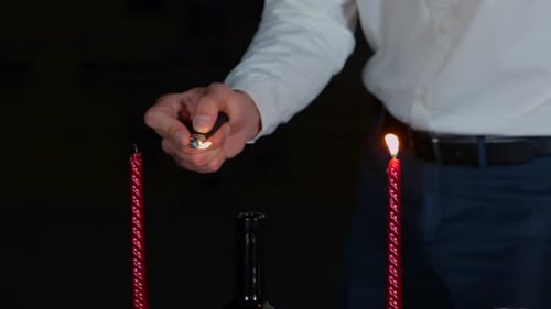 Man Lighting Candles on Romantic Dinner Table