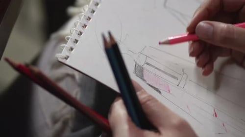 Fashion Designer Sketching Garment with Colored Pencils