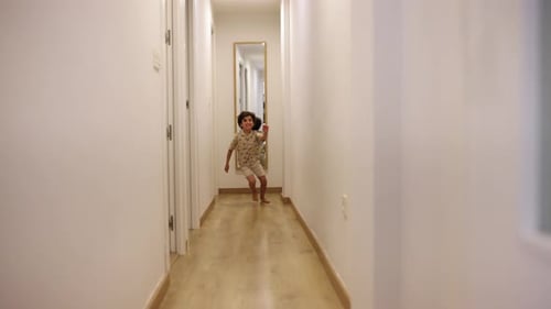 Criança feliz correndo no corredor em casa