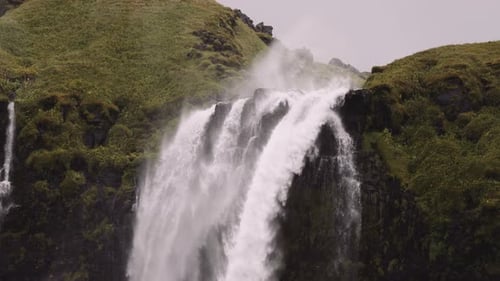 Majestic Waterfall Cascading Down Mossy Green Cliffs