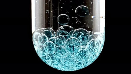 Blue Bubbles Rising in Test Tube Close Up