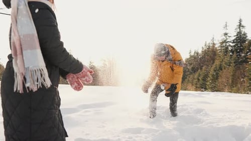 Friends Have Snowball Fight in Winter Sunlight