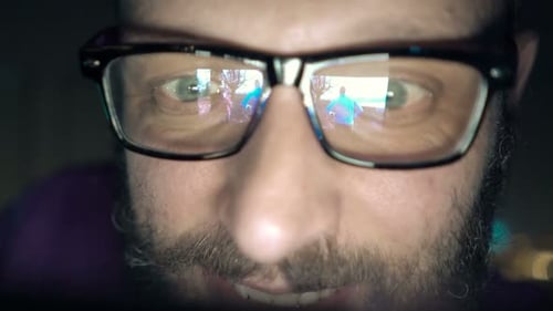 Man With Glasses Watching Movie On Smartphone At Night