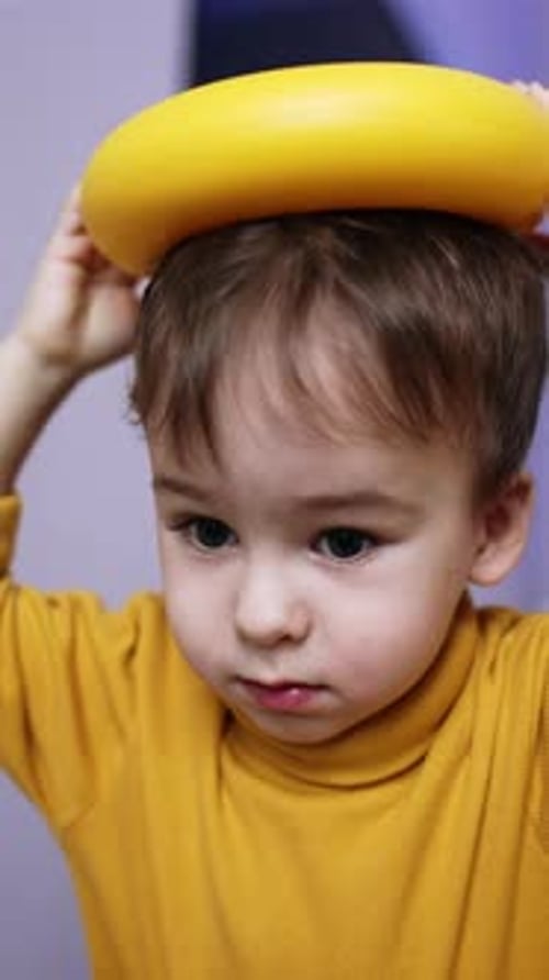 Un hermoso niño moreno con suéter amarillo juega con juguetes.