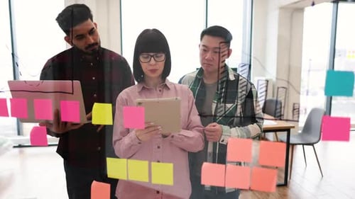 Team-Brainstorming mit Haftnotizen und digitalen Geräten im modernen Büro