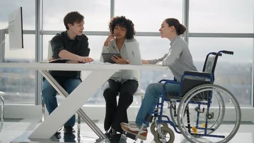 Friendly Colleagues Working on Project in Office Together Sitting at Table Woman in Wheelchair with