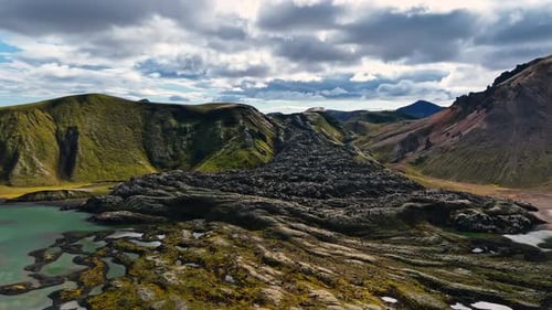 Drone View Of Lava Fields And Turquoise Lake In Landscape Capturing Dramatic Volcanic Terrain