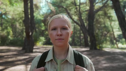 A Pretty Tourist Woman Walks with a Briefcase Through a Beautiful Forest