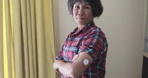 Woman Showing Medical Sensor on Arm in Home
