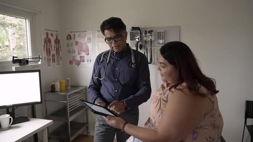 Doctor and Patient Reviewing Records on Tablet