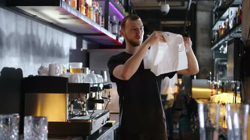 Bartender Polishing Glass in Stylish Urban Bar