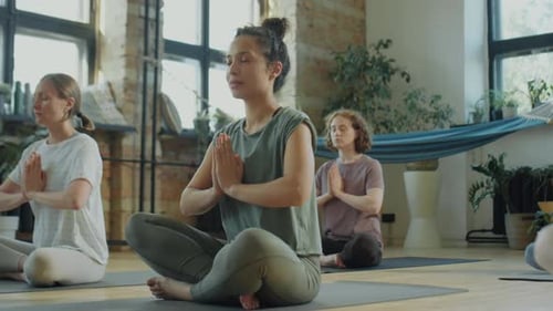 Group Doing Yoga and Meditation in Studio
