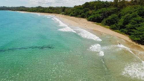 Long tropical surfing beach in Costa Rica on sunny day