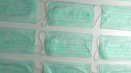 Surgical Face Masks Arranged on Clean White Surface