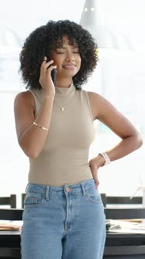 Vidéo verticale : Prendre une femme qui consulte le téléphone et parle du travail dans une cuisine lumineuse en haut beige
