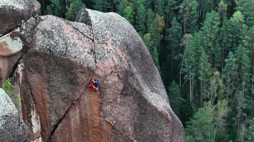 Rock Climber Ascending Steep Mountain Cliff Face