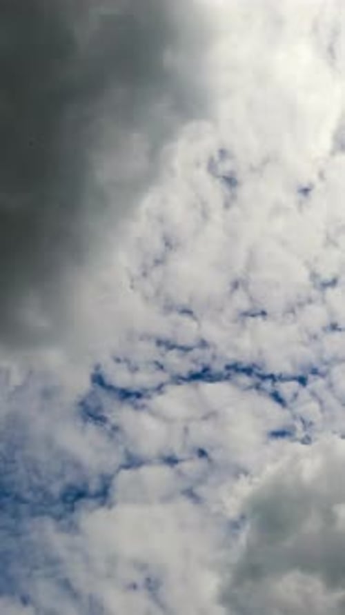 Cumulus clouds floating by the bright blue sky. White and grey clouds fully covering the horizon.
