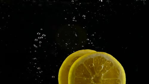 Two Lemon Slices Falling Into Water