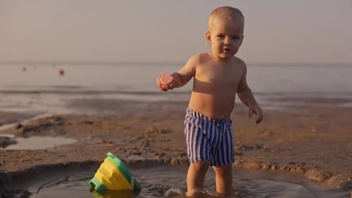 A Happy Toddler Joyfully Playing By the Beach During a Beautiful Sunset That Enhances the Scenic