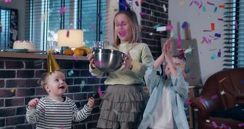 Cute Happy Teenage Girl Throwing Confetti in the Air Celebrating Birthday Party with Two Little