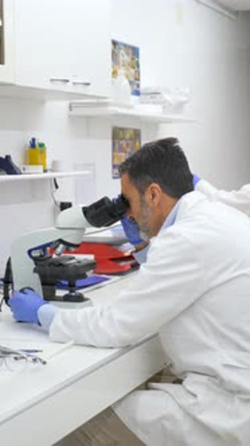Scientifique regardant au microscope travaillant dans un laboratoire de biochimie