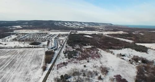 Drone flying towards Blue Mountain ski hill in winter.