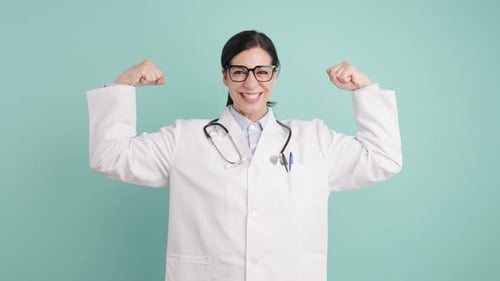 Femme médecin forte fléchissant les biceps et souriant