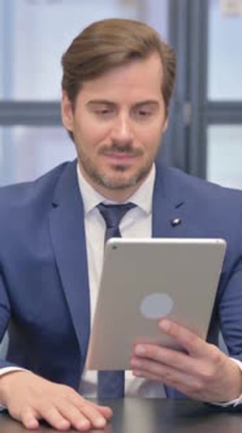 Man in Suit Video Conferencing Using a Tablet