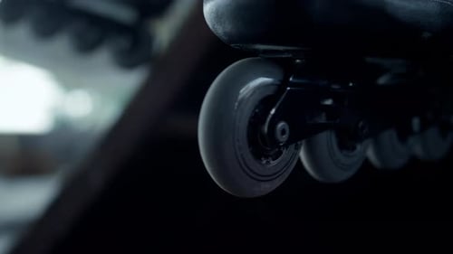Unerkennbare Athletenbeine, die sich nach dem Rollschuhtraining im Skatepark ausruhen