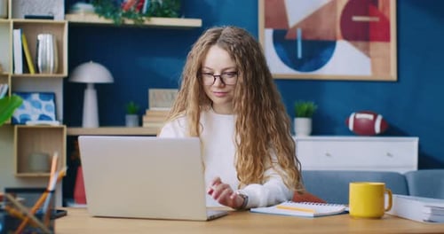 Smiling Young Woman Chatting in Internet on Laptop Indoor Home Background Cheerful Girl Sitting at