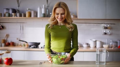 Woman with Salad Bowl Smiling in Bright Kitchen