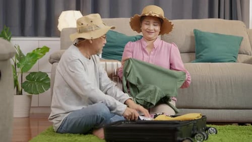Mature Couple Packing Suitcase for Vacation Together