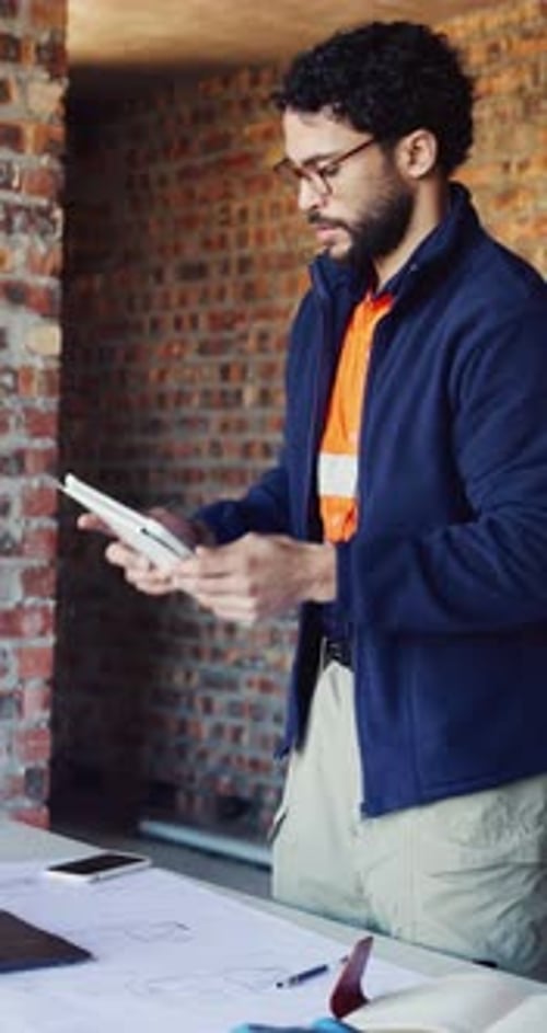 Tablet, inspection and man on laptop at construction site for progress report, building code or RFI